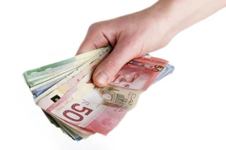 Hand holding Canadian banknotes as a cash incentive